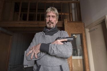 John McAfee pose, arme à la main, en 2015.